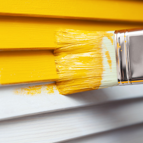 yellow paint is applied to a white wooden wall with a brush yellow paint is applied to a white wooden wall with a brush